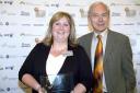 Catherine Holt receives her award from broadcaster John Humphrys