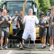 Jack Otter walks with the OIympic torch in The Green, Southgate