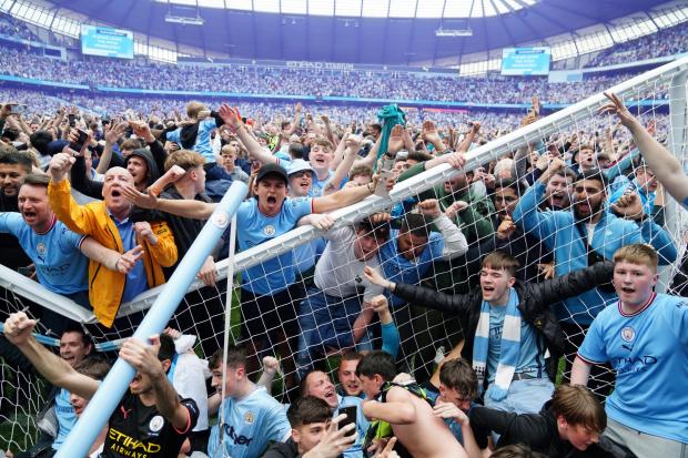 Manchester City fans invade the pitch after their side win the Premier League